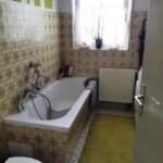 Wannenbad im Erdgeschoß mit Fenster und alten Fliesen