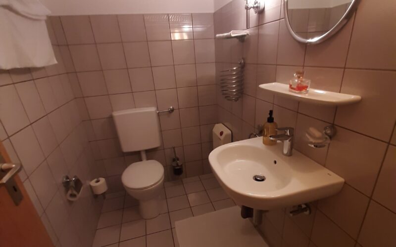 Gut ausgestattetes Gäste-WC im Untergeschoss des Hauses in Iserlohn. Es ist der Wohnfläche hinzuzurechnen. Es hat ein fenster an der linken Seite.