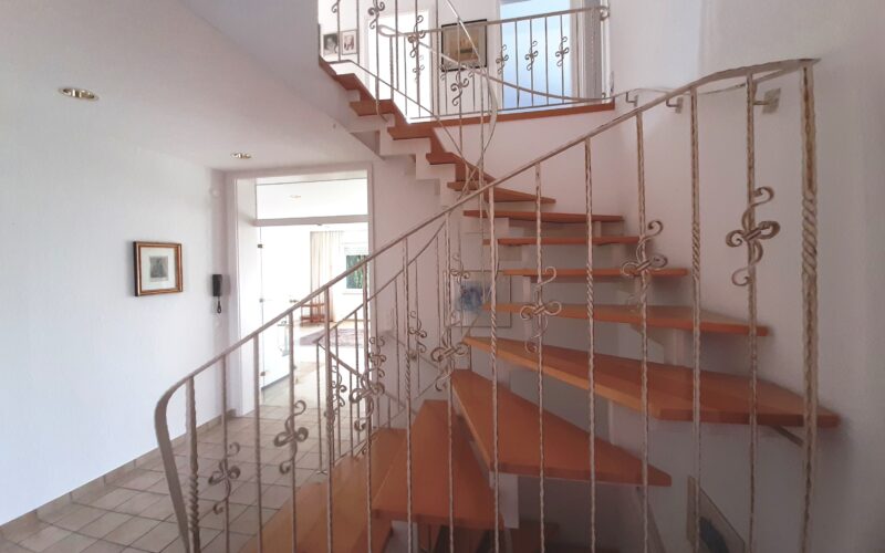 stielvolles Treppenhaus mit Galerie und Blick ins Wohnzimmer