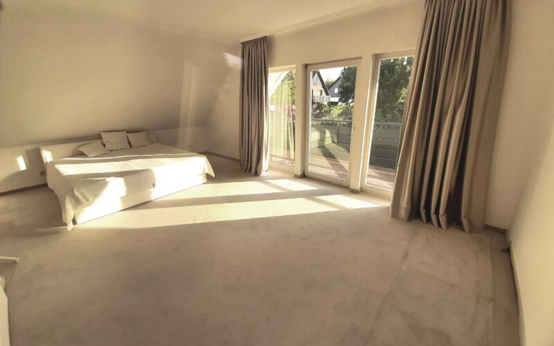 Schlafzimmer im Dachgeschoß des Einfamilienhauses in Iserlohn-Sümmern mit Blick auf die Loggia und auf Sümmern