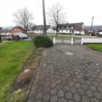 Blick vom Hauseingang zur Straße mit Dorfanger. Hier befinden sich Stellplätze für zwei Autos