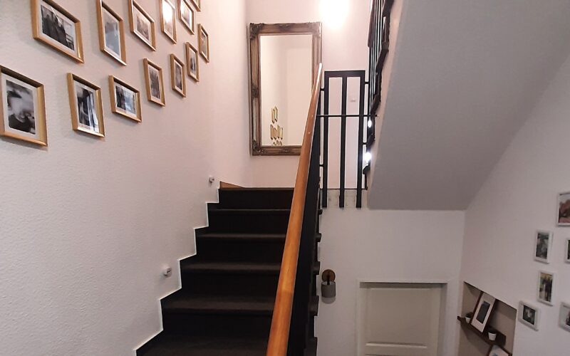 Das helle, lichtdurchflutete Treppenhaus des Einfamilien-Reihenhauses in Hemer. Hier geht es zum Obergeschoß und zum Dachgeschoß.