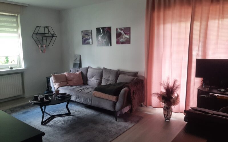 Wohnzimmer mit Zugang zur Loggia und zur Küche von der Diele aus betrachtet.