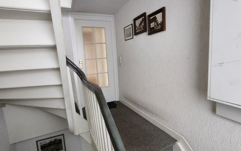 Treppenaufgang zur Wohnung im Obergeschoß des Mehrfamilienhauses im Menden. Gerne vereinbaren wir mit Kausinteressenten einen Besichtigungstermin.