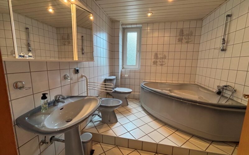 Im ersten Obergeschoß des Hauses in Fröndenberg gibt es ein Tageslicht-Badezimmer mit großer Eckwanne und luxuriöser Ausstattung.