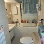 Tageslicht-Bad mit Badewanne, Waschtisch und WC im ersten Obergeschoß. der Fußboden ist gefliest.