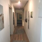 Dieses ist die Diele im ersten Obergeschoß. Sie hat fünf Türen die in verschiedene Räume führen und einen Laminat-Fußboden auf dem zei texile Läufer liegen.