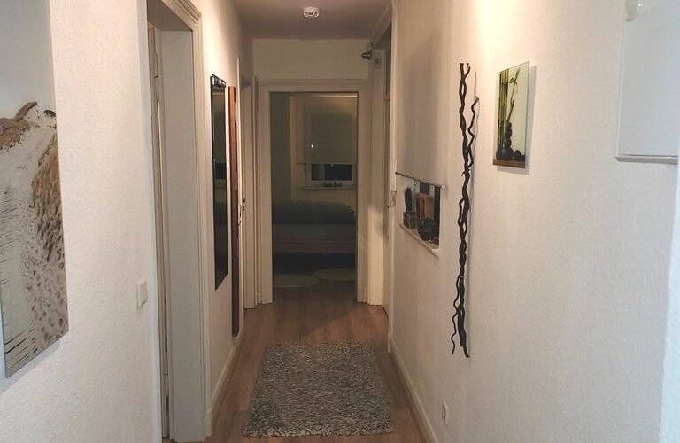 Dieses ist die Diele im ersten Obergeschoß. Sie hat fünf Türen die in verschiedene Räume führen und einen Laminat-Fußboden auf dem zei texile Läufer liegen.