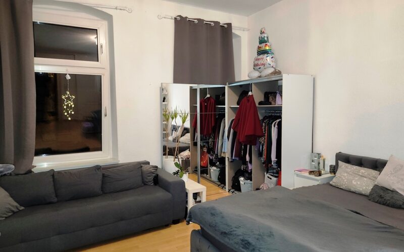 Das Kinderzimmer im ersten Obergeschoß hat zwei Fenster. Die Wände sind weiß gestrichen. Das Licht ist an. Die Fenter haben Vorhänge.