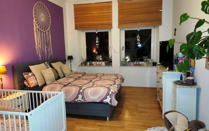 Ein geschmackvoll eingerichtetes Schlafzimmer im ersten Obergeschoß mit schöner Dekoration und einem Kinderbett.