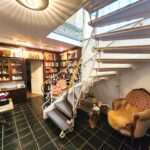 Die Helle geräumige Diele im Souterrain ist gleichzeitig als Bibliothek ausgestattet. Helle Wände und dunkle hochwertige Bodenfliesen bestimmen das großzügige Raumgefühl.