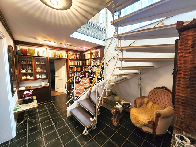 Die Helle geräumige Diele im Souterrain ist gleichzeitig als Bibliothek ausgestattet. Helle Wände und dunkle hochwertige Bodenfliesen bestimmen das großzügige Raumgefühl.