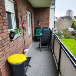 Auf dem Balkon seht eine Mülltonne mit gelbem Deckel