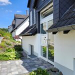 Eingang zur Appartement-Wohnung in Iserlohn-Sümmern. Helle Eingangsanlage mit Briefkästen, Klingeln und Sprechanlage.