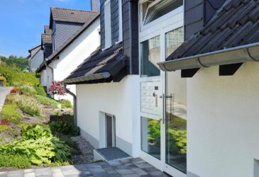 Eingang zur Appartement-Wohnung in Iserlohn-Sümmern. Helle Eingangsanlage mit Briefkästen, Klingeln und Sprechanlage.