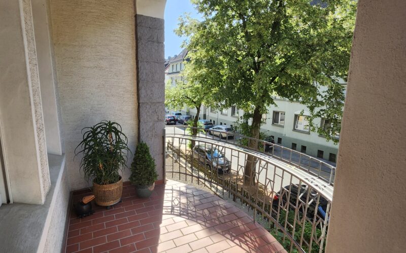 Balkon zum 4 Familienhaus in Iserlohn im Jugendstil mit Blick auf Bäume und die aus Wohnhäusern bestehende Straße in Iserlohn
