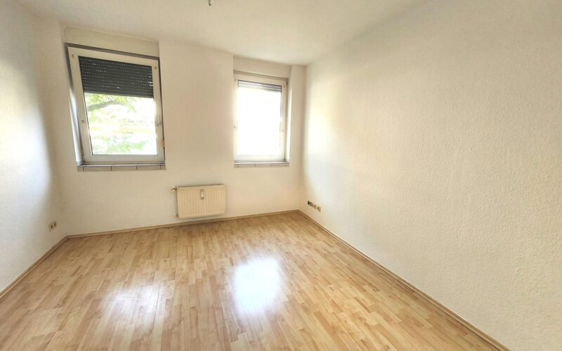 Das helle, geräumige Wohnzimmer in der Mietwohnung in Iserlohn verfügt über zwei große Fenster mit Rollläden.